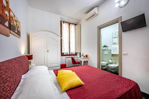a bedroom with a red and white bed and a bathroom at Il Viaggiator Leggero in Florence