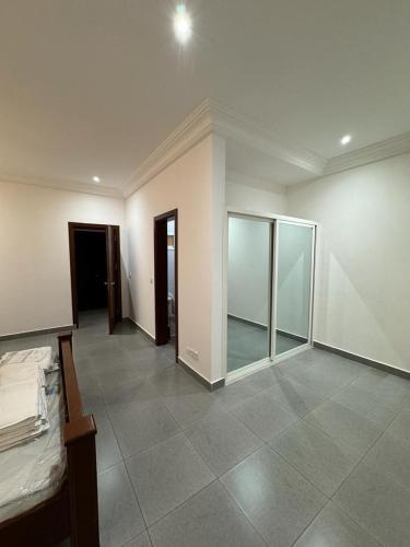 an empty room with a bed and a room with mirrors at Duplex grenade in Tchimbanmba