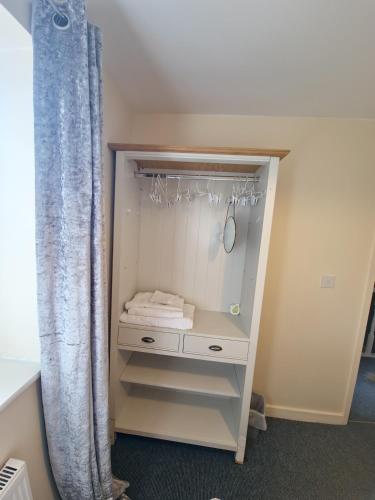 a closet with a white dresser and a shower curtain at 3 Bed Entire House - Runcorn in Runcorn