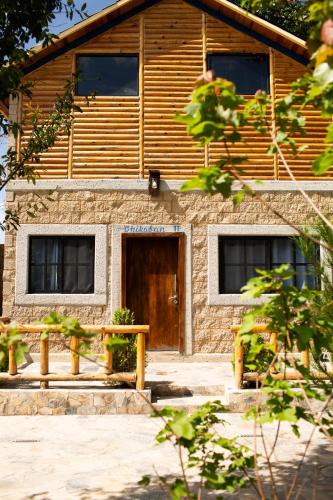 a building with a wooden door in front of it at Cabañas Bungalos las Alazanas in San Antonio de las Alzanas