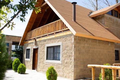 a brick house with a balcony on top of it at Cabañas Bungalos las Alazanas in San Antonio de las Alzanas