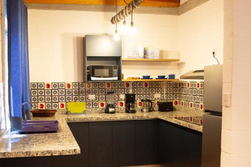 a kitchen with a counter top with a microwave at Cabañas Bungalos las Alazanas in San Antonio de las Alzanas