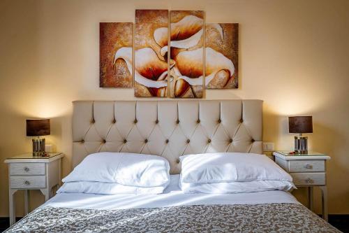 a bedroom with a bed with three paintings on the wall at Il Viaggiator Leggero in Florence