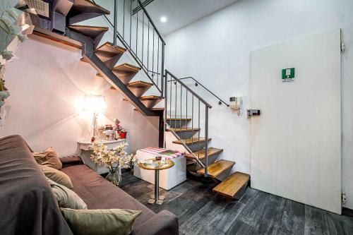 a living room with a couch and a staircase at Il Viaggiator Leggero in Florence