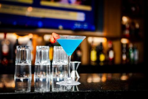 a blue drink in a martini glass on a bar at Camino Real Acapulco Diamante in Acapulco