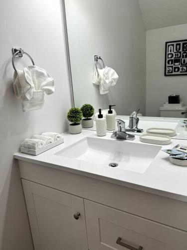 a white bathroom with a sink and a mirror at Bright Spacious Renovated Home Master on Main in Winder