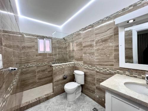 a bathroom with a toilet and a sink and a mirror at Casa Linda 756 - 5br Modern Villa In Sosua in Sosúa