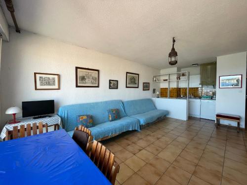 un salon avec un canapé bleu et une cuisine dans l'établissement Studio face à la mer avec terrasse et parking - FR-1-309-44, à Banyuls-sur-Mer