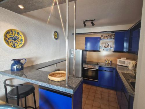 une cuisine avec des armoires bleues et un comptoir dans l'établissement Appartement 2 pièces, vue mer, près port, 4 pers, parking, ascenseur, Sainte-Maxime - FR-1-780-51, à Sainte-Maxime