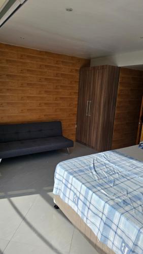 a bedroom with a bed and a couch at Lydia's House in Kaputian