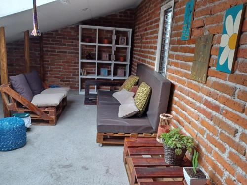 a patio with a couch and a chair and a table at Hostal Mochiliers Bed and Breakfast in Cuenca