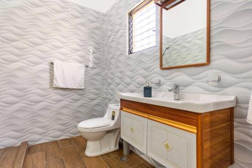 a bathroom with a sink and a toilet at Casa para vacacionar - El patio de Olivia in San Felipe de Puerto Plata