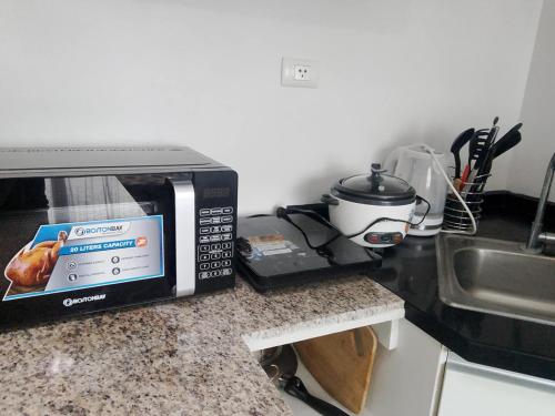 a microwave oven sitting on a counter next to a sink at Avida Tower 1 in Cagayan de Oro