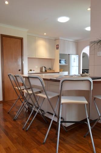 a kitchen with a table and chairs in it at Dolphin Lodge Albany - Self Contained Apartments at Middleton Beach in Albany