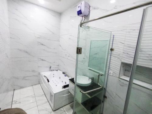 a bathroom with a glass shower and a sink at Hibiscus Empire in Ikota