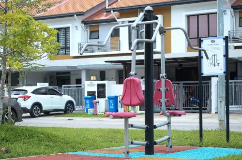 a playground in front of a house with a car at Modern 4BR Double Storey @ Setia Alam in Shah Alam