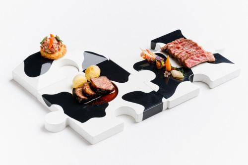 two pieces of a puzzle with different foods on it at The Ritz-Carlton Tenerife, Abama in Guía de Isora