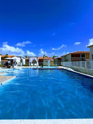 a large swimming pool with blue water at Ap 2 quartos tipo resort pé na areia 1 in Barra dos Coqueiros