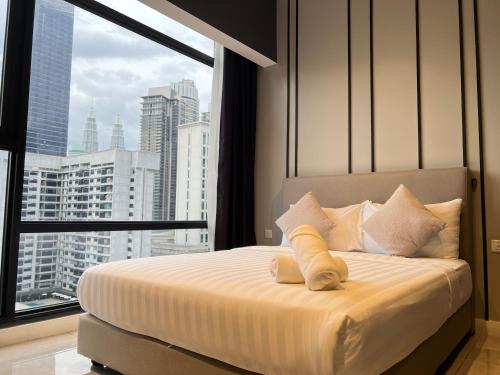 a bedroom with a bed with a view of a city at Axon suites Bukit bintang Rooftop Swimming pool in Kuala Lumpur