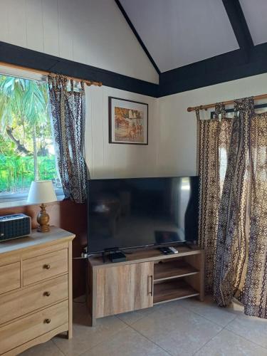 a living room with a large flat screen tv at Villa VAIROARII Moorea in Afareaitu