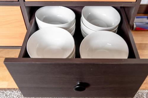 a wooden box with white dishes in it at KAKUREGA by unito in Hakodate