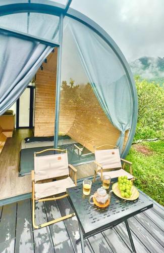a table with two chairs and a plate of grapes at Ora Hill Retreat in Cao Phong