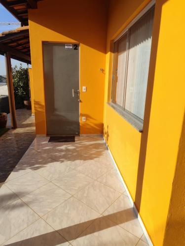 a yellow building with a door and a window at chalés duas irmãs in Serra Negra