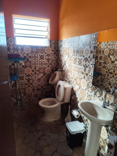 a bathroom with a toilet and a sink at chalés duas irmãs in Serra Negra