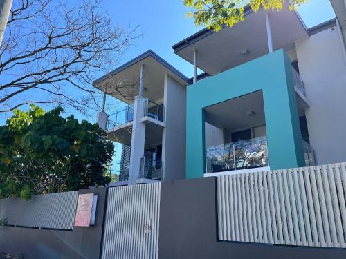 a house with a white fence in front of it at Cirque Boutique Apartments - Hosted by Coastal Letting Co. in Brisbane