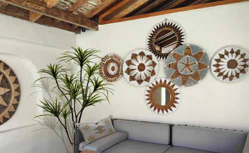 a room with plates on a wall with a couch at Kaleydo Villas in Gili Trawangan