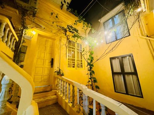 a yellow building with a staircase and a window at Azalea Apartment in Hanoi