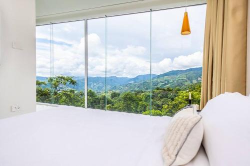 Schlafzimmer mit einem großen Fenster mit Bergblick in der Unterkunft Mountain Skyline House Best View Doi Sakad Nan V2 in Pua