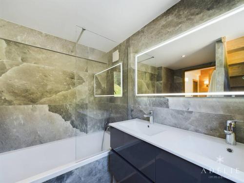 une salle de bain avec un lavabo et un miroir dans l'établissement Luxueux Appartement 8 Pers, SPA, Près des Pistes, Parking, WIFI - FR-1-398-667, à Montvalezan