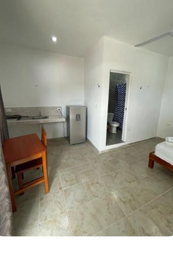 a living room with a table and a kitchen at DePARTAMENTO AF 14 in Tizimín
