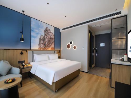 a bedroom with a large white bed and a couch at Campanile Shanghai Oriental Beauty Valley Avenue Xianpu Road in Fengxian