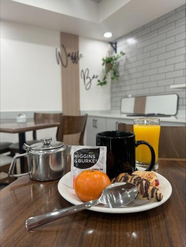 a plate of food with an orange on a table at Prestige Prince George Lodge in Prince George