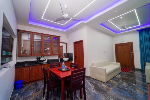 a kitchen with a table and a living room at Skylar Seaview Beach Resort & Ayurveda Varkala in Varkala