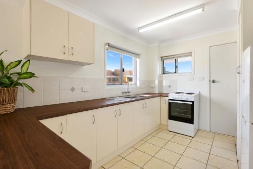 a kitchen with white cabinets and a sink at Apartment 7T in Lennox Head