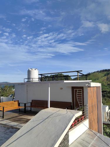 a building with a ramp and a bench on a roof at Kodai Diva Inn - Home Stay in Kodaikānāl