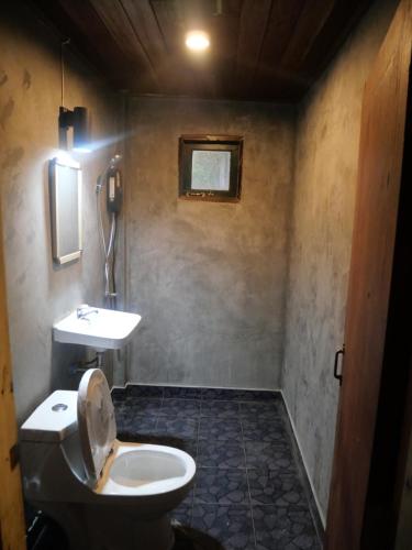 a bathroom with a toilet and a sink at Hug Doi Homestay in Ban Wo