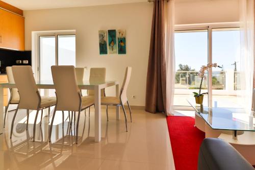 a dining room and living room with a table and chairs at Villa Fuseta 102 T in Fuzeta