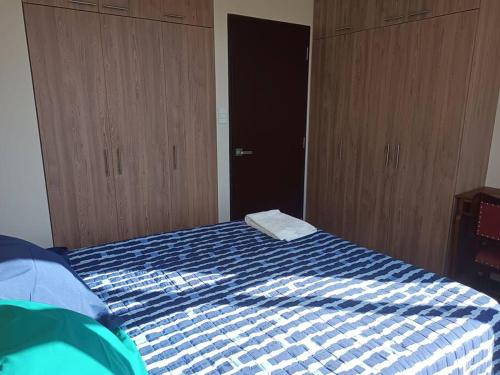 a bedroom with a bed with a blue and white blanket at Loft en La Paz in Chijini