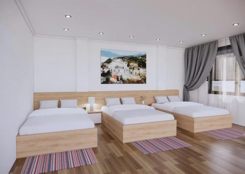 a bedroom with two beds and a painting on the wall at Sơn Trang House in Sa Pa