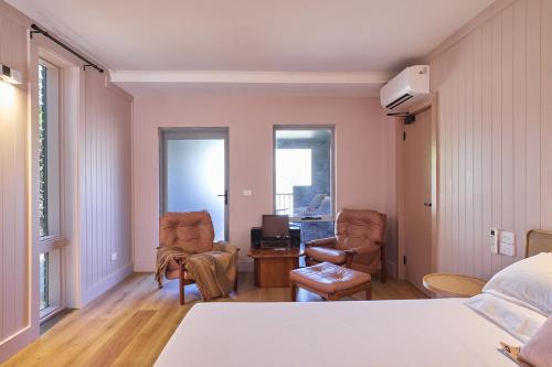a bedroom with a bed and two chairs and a desk at Alpine Inn in Khancoban