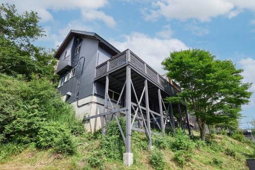 a house on top of a hill with trees at The No 10 Fuji Yamanakako in Yamanakako