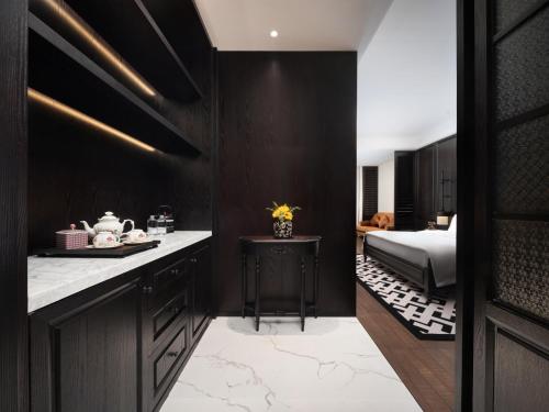 a kitchen with black walls and a bedroom with a bed at Anlandon International Hotel in Qingbaijiang