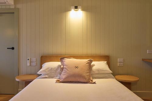 a bedroom with a bed with a light on the wall at Alpine Inn in Khancoban