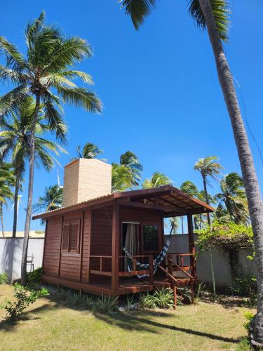eine Hütte am Strand mit Palmen in der Unterkunft Vila do Rico in São Gonçalo do Amarante