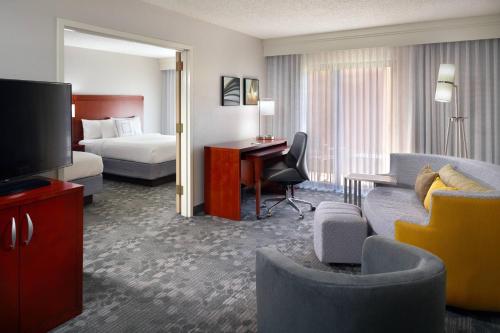 Una habitación de hotel con una cama y una sala de estar. en Courtyard by Marriott Macon, en Macon