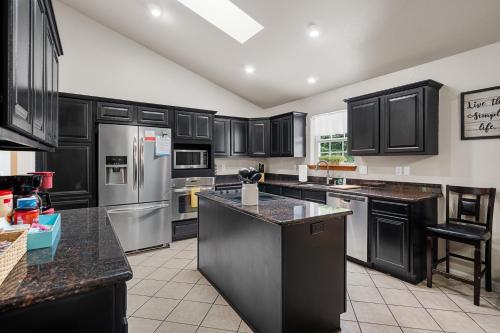 a kitchen with black cabinets and stainless steel appliances at Pool, Hot Tub, Game Room & Sleeps 18! By StayLage in Hot Springs